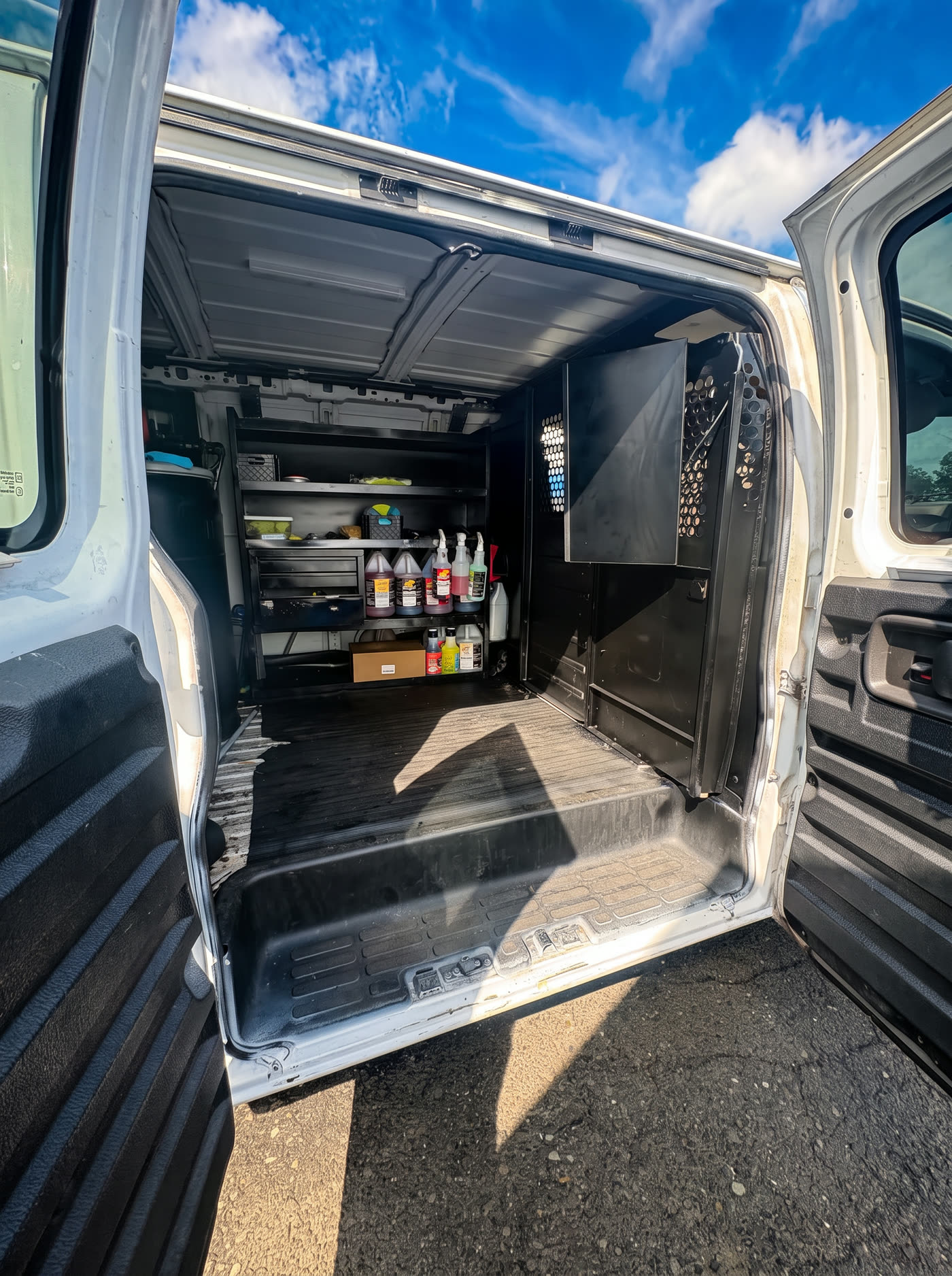 Shelved professional detailing chemicals inside the Wax N' All van