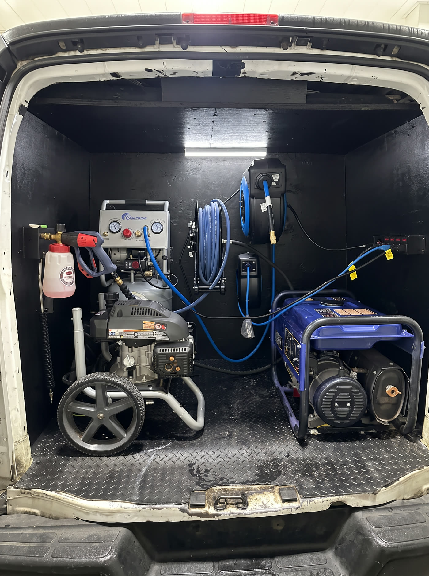 Pressure washer, generator, and hose reels inside the Wax N' All rig